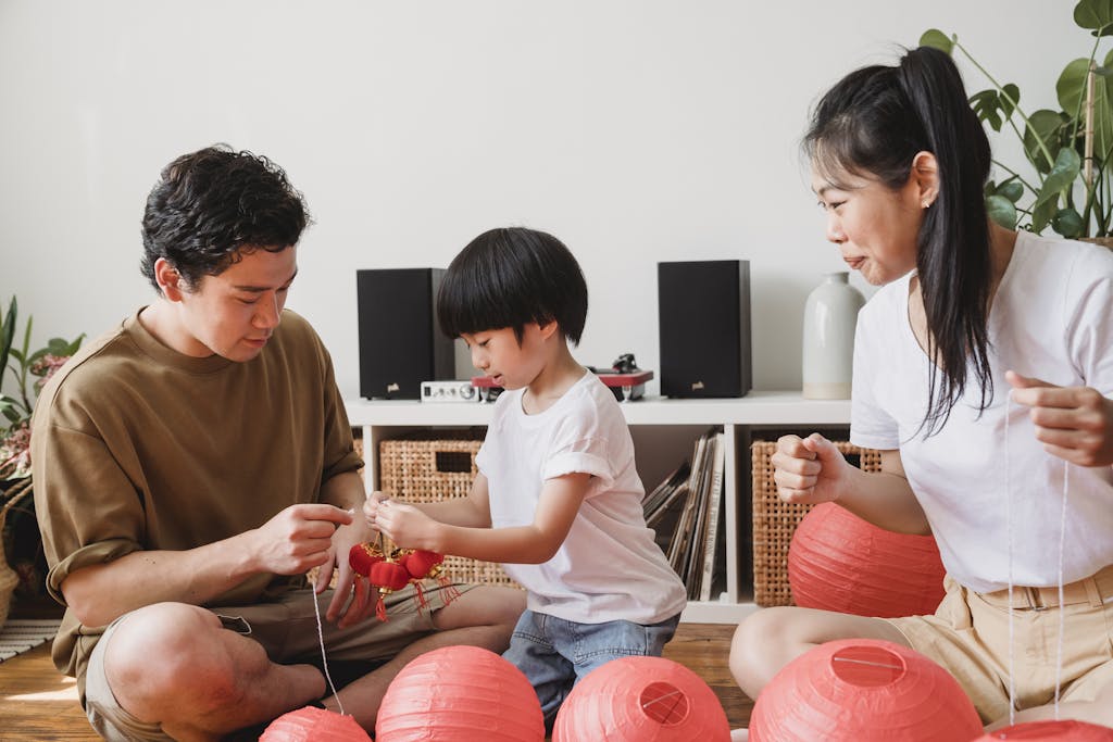 A family bonding with red lanterns indoors, capturing Asian cultural traditions.