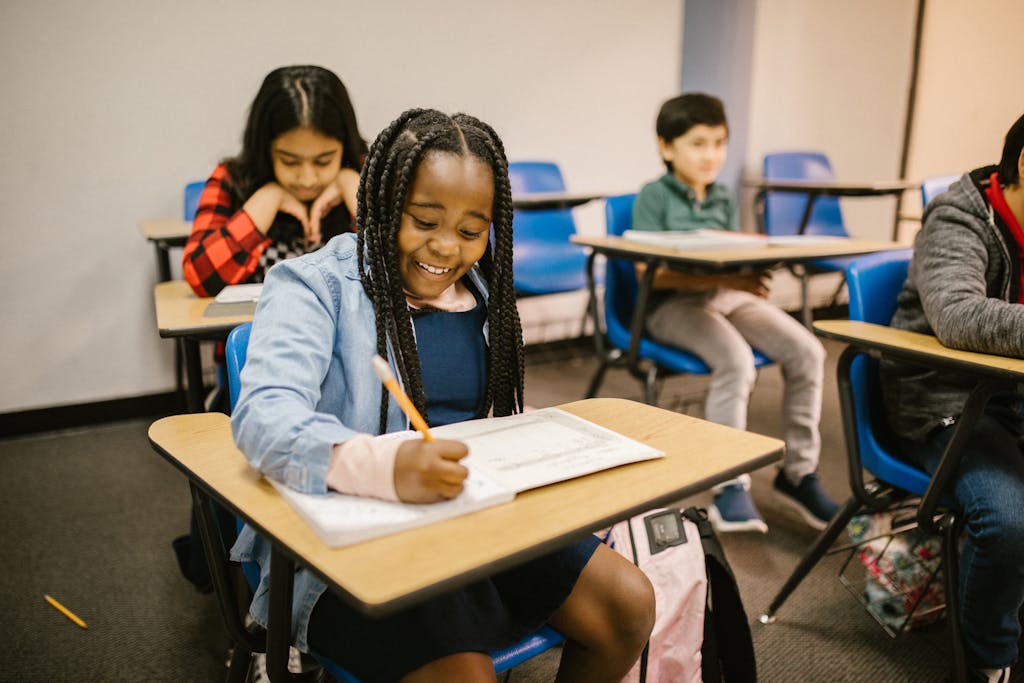 A group of diverse children focused on their tasks in a classroom setting, promoting education.