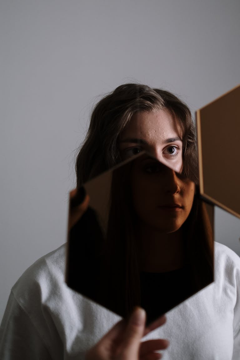 A unique portrait of a woman reflected in a broken mirror, evoking emotion and introspection.