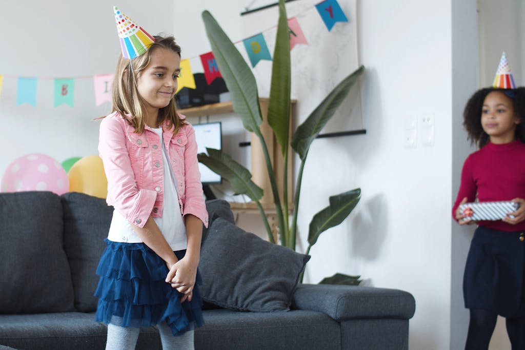 Cheerful children celebrating a birthday party indoors with colorful decorations in Portugal.