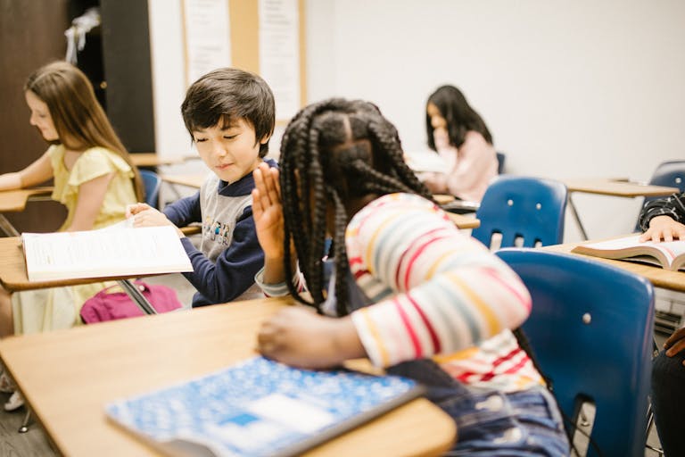 Children from various backgrounds engaged in classroom conversation, promoting education and diversity.