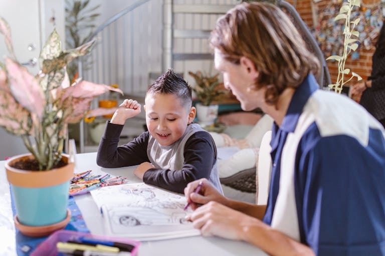 Father and son enjoy quality time and creativity while coloring together indoors.