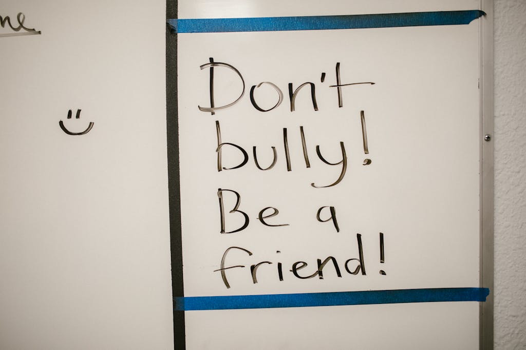 Message against bullying written on a whiteboard, promoting friendship.