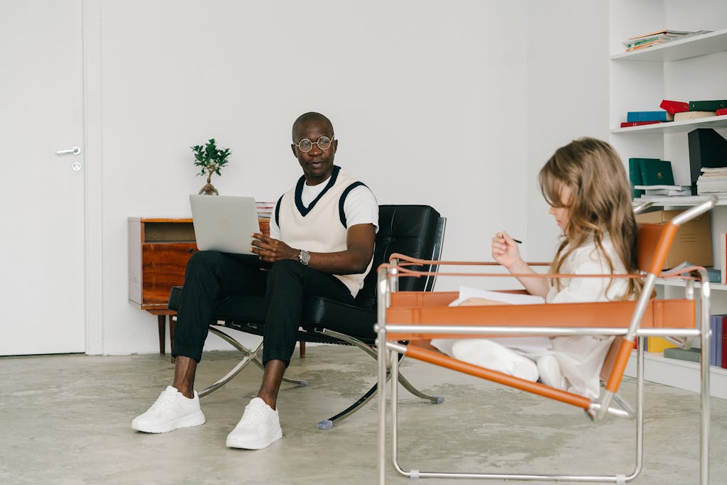 Psychologist and young girl in a therapy room, engaging in conversation and analysis.