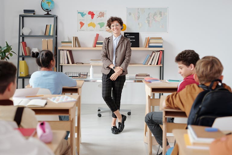 Teacher engaging with diverse students in a modern classroom setting for education.